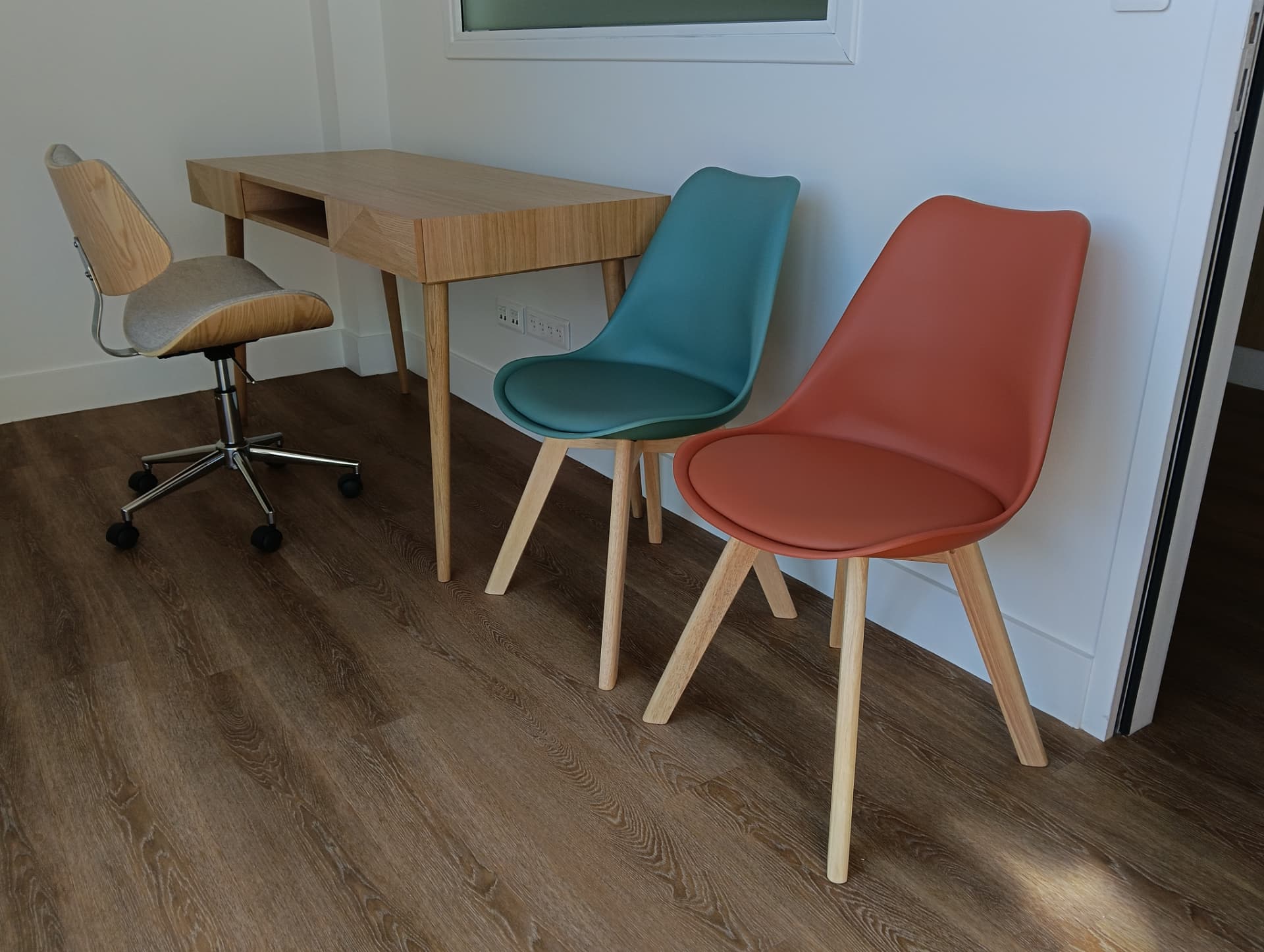 Aménagement d'un espace bureau : bureau bois, chaise de bureau design et chaises visiteurs bleu canard et terracotta — locaux professionnels à Chambéry